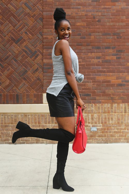 Woman Holding Red Leather Bag Standing Near Wall