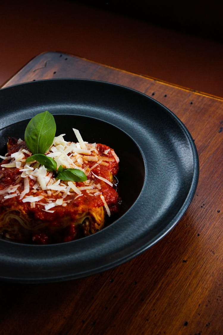 Mouthwatering Lasagna On Black Ceramic Plate