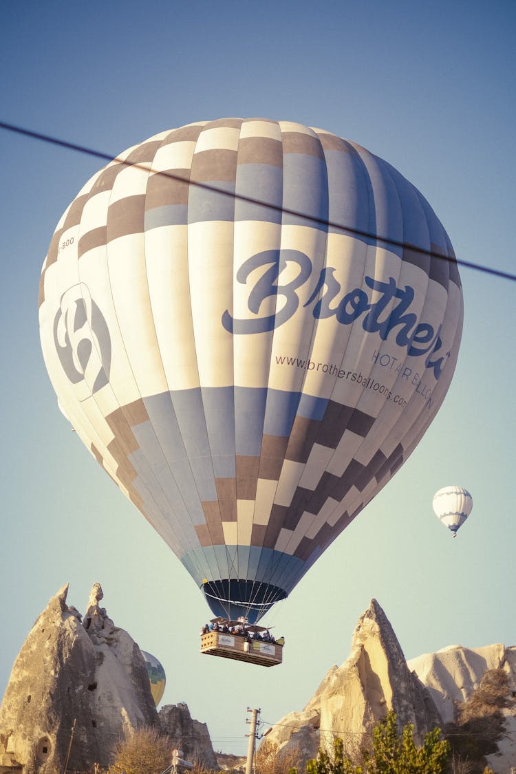 Hot Air Balloon On Mid Air Near Rocky Mountains