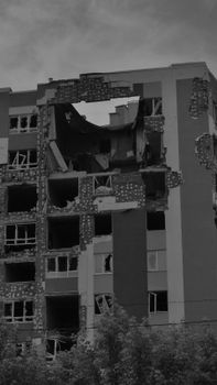 A stark black and white image capturing the facade of a destroyed apartment building in Irpin, Ukraine.