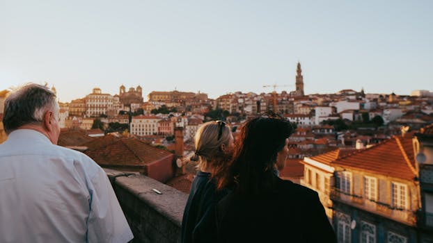 Group of tourists overlooking the stunning rooftops and cityscape of Porto, Portugal at sunset.