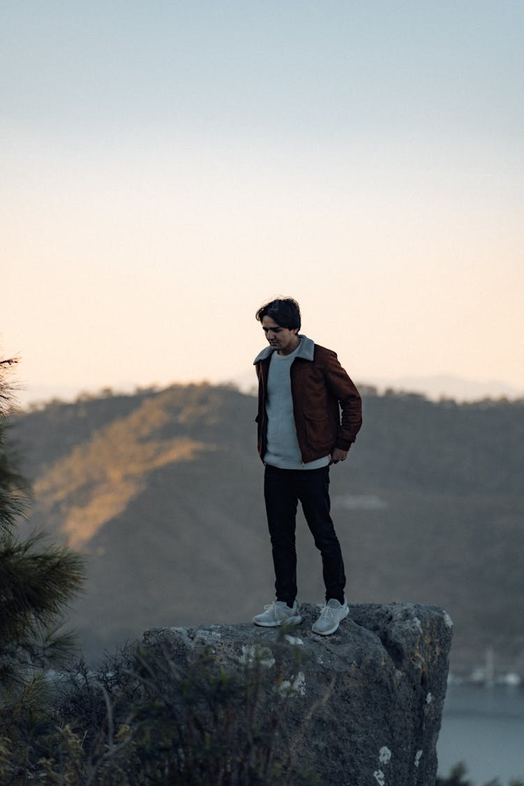 Man Standing On A Rock In The Mountains