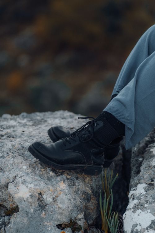 Free Stylish black shoes on a rocky terrain, captured in a serene outdoor setting. Stock Photo