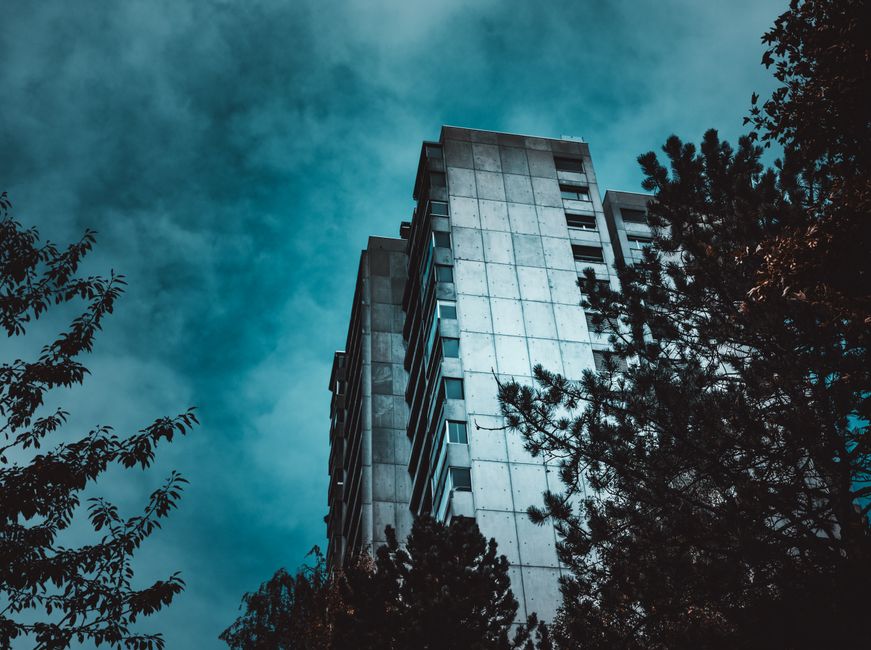Low angle view of a contemporary high-rise building against a dramatic sky in Bern, Switzerland.