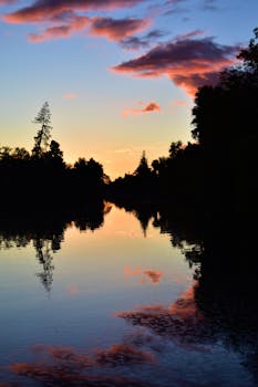 Beautiful sunset reflected on a pristine lake with dramatic clouds and serene surroundings.