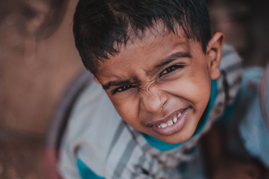 A close-up of a young boy making a funny face, capturing a playful moment outdoors.