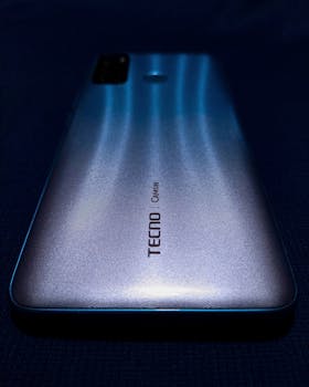 Artistic shot of a blue smartphone with strong light reflections, focusing on design aesthetics.