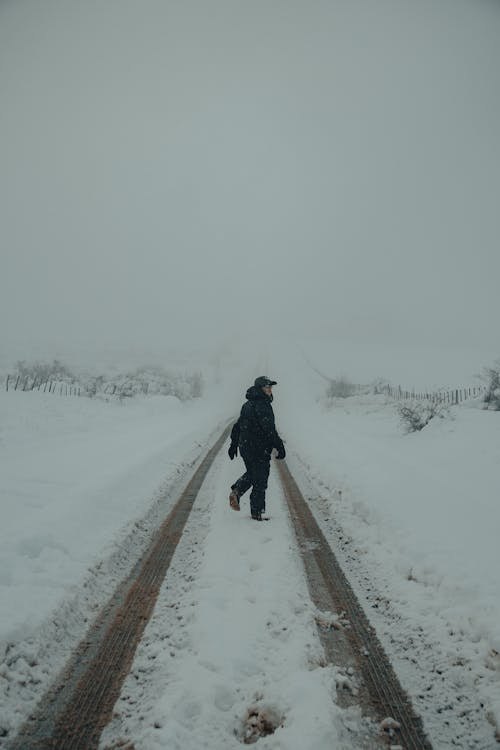 Man on Snowy Road in Winter