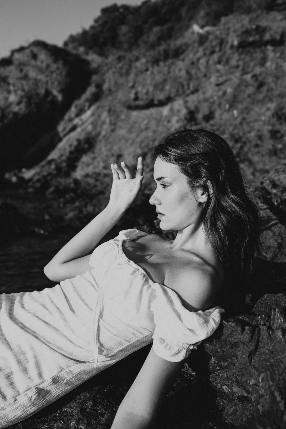 A woman in a white off-shoulder dress by the seashore — the romantic off-shoulder