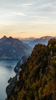 A breathtaking aerial shot of a mountain landscape in autumn, featuring a serene body of water.