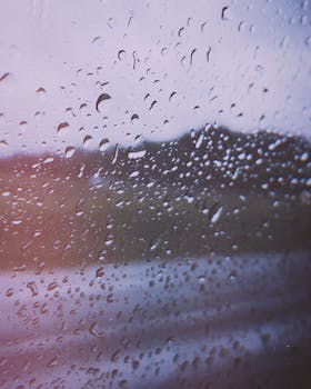 Close-up of raindrops on a window with a blurred outdoor view in Ribeirao Preto, SP, Brazil.