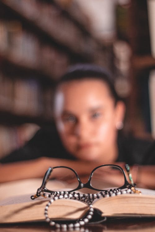 Black Framed Eyeglasses on Top of an Open Book
