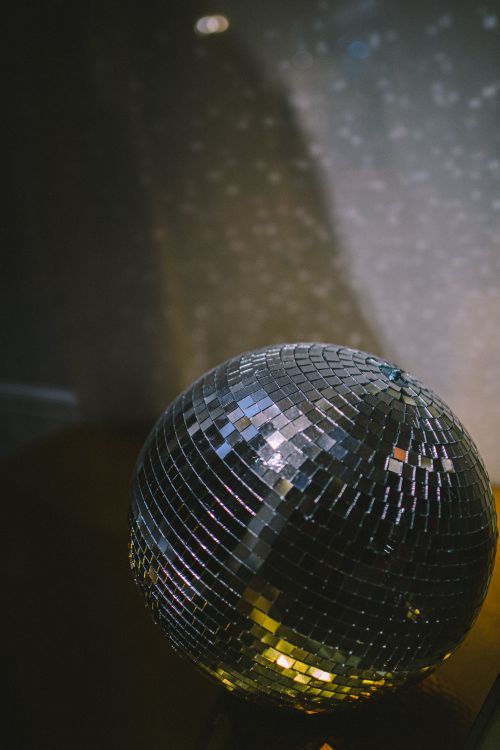 Free A shimmering disco ball displays dazzling reflective light patterns in a dimly lit room. Stock Photo
