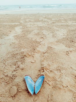 A tranquil beach scene with a blue seashell on the sandy shore, capturing summer relaxation.