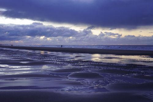 Free Dramatic twilight sky over Oostende beach with reflections on the sand and sea. Stock Photo