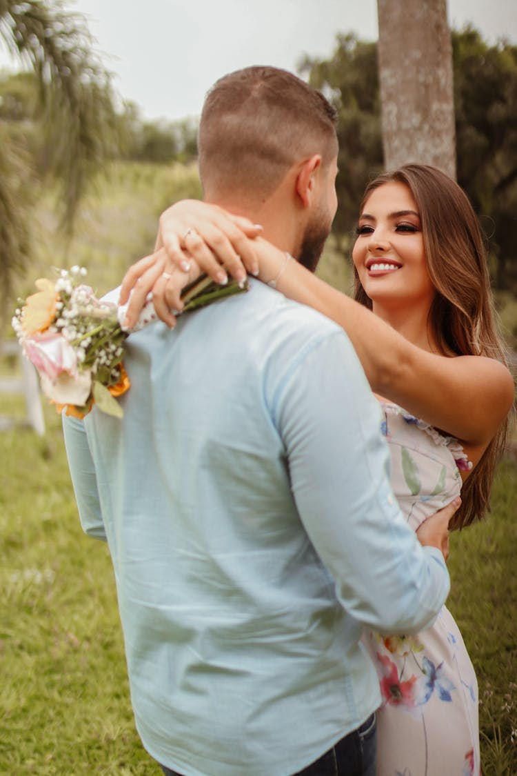 A Couple Hugging While Looking At Each Other