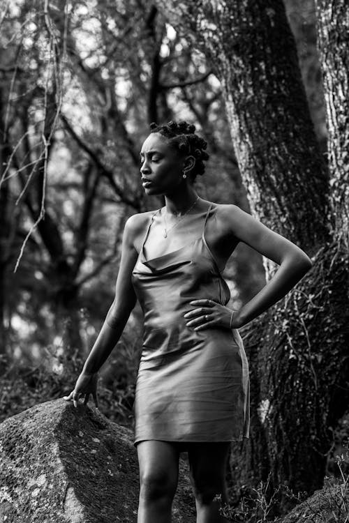 Black and White Photo of a Woman Posing near a Tree