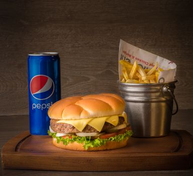 Appetizing cheeseburger served with fries and soda for a perfect fast food meal.