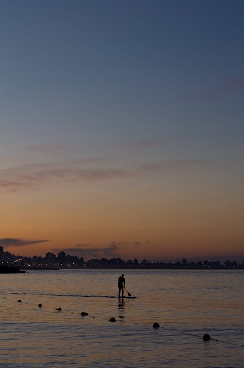 Photo of Person on Sea during Dawn