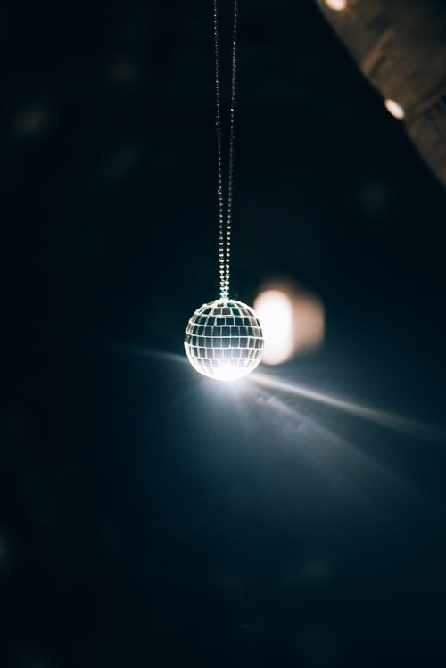 Free A glowing mirror ball hanging in a dark room, reflecting light elegantly. Stock Photo