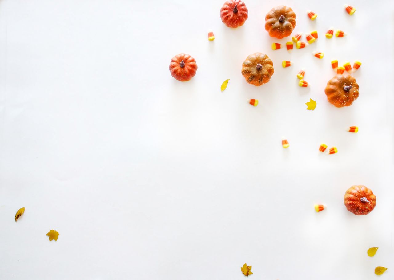 minimalist autumn themed flat lay with mini pumpkins and candy corn on