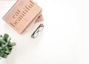 Brown Framed Eyeglasses Beside Eat Beautiful Book