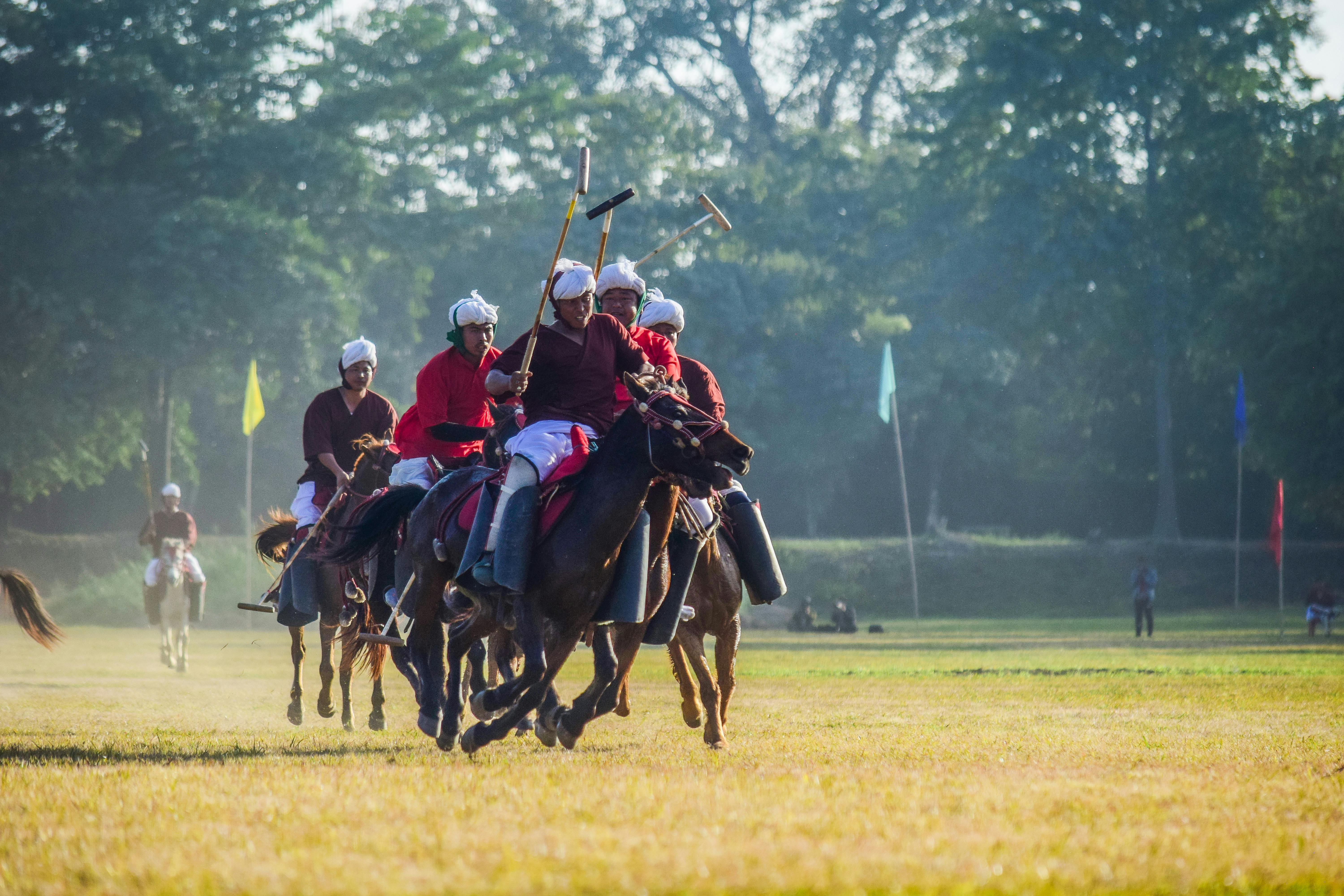 men riding horses and playing polo