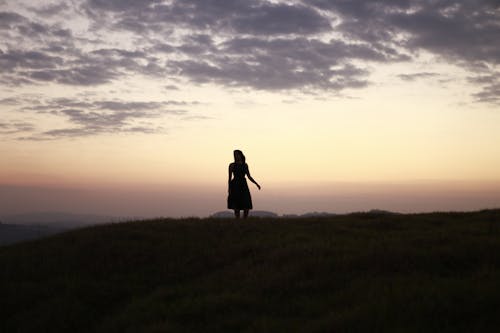 Darmowe zdjęcie z galerii z kobieta, pochmurne niebo, pole trawy