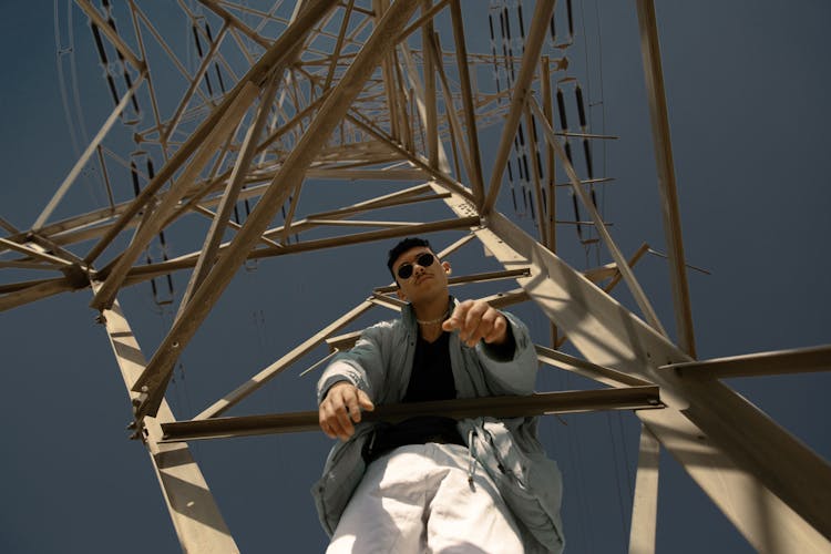 A Man Climbing A Steel Tower