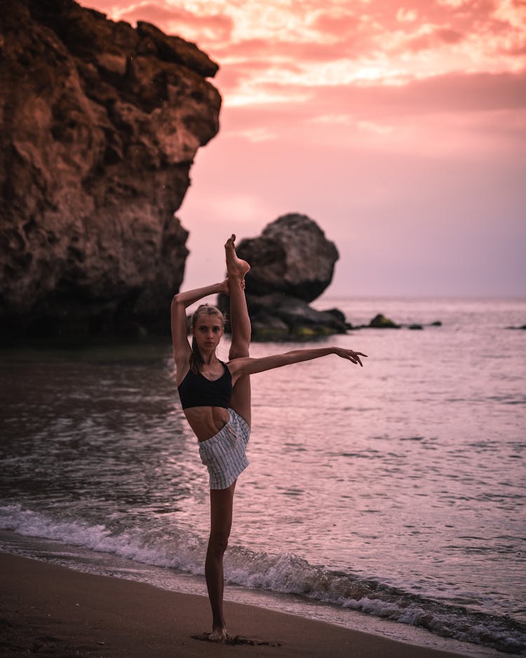 Slim Girl Practising Yoga On Beach At Sunset