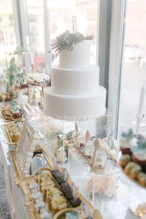 Free White tiered wedding cake with succulent decor on a luxurious dessert table. Perfect for celebrations. Stock Photo