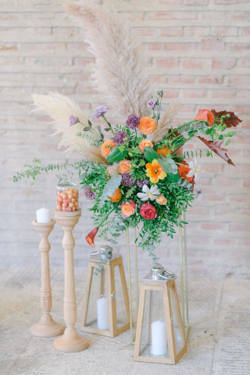 Free Elegant floral centerpiece with candles and lanterns, a perfect decor for weddings and gatherings. Stock Photo