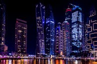 夜晚，迪拜码头的摩天大楼灯火通明，倒映在水面上