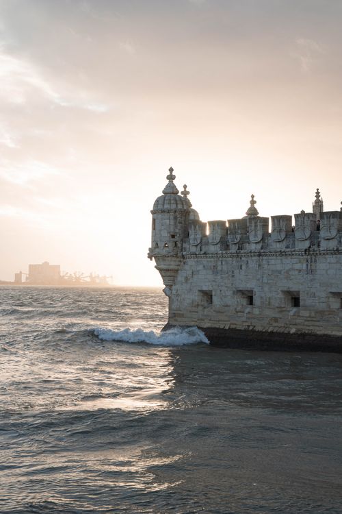 Free Capture the beauty of Belem Tower at sunset in Lisbon, Portugal, featuring serene waters and historic architecture. Stock Photo