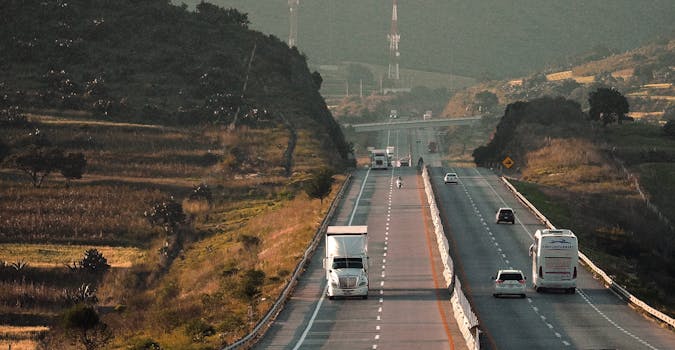 A bustling highway scene showcasing various vehicles traveling through a picturesque landscape.