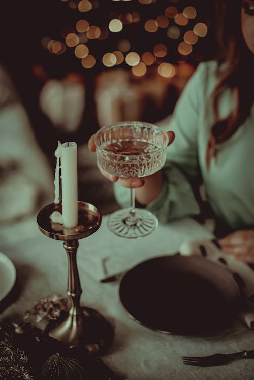 Woman Holding a Cocktail at a Christmas Dinner Party 