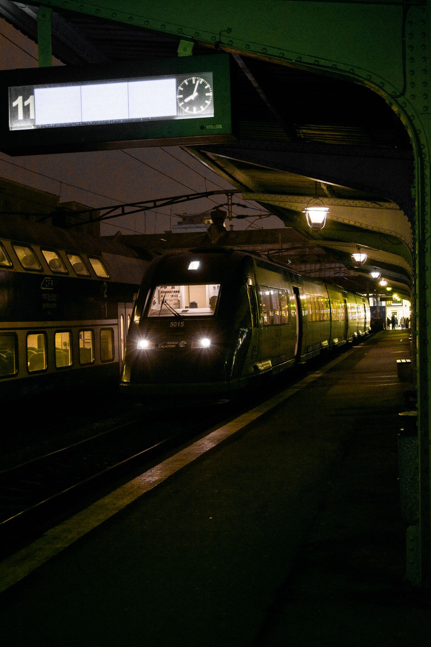 Train at a dimly lit station platform at night