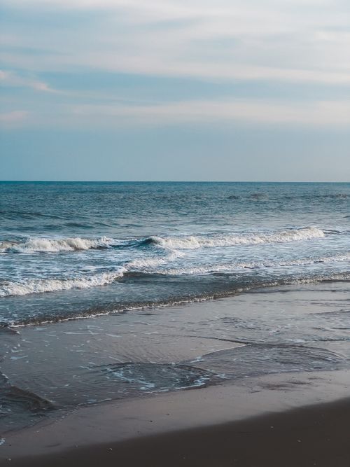 Free Serene ocean waves gently washing ashore on a picturesque Thai beach, ideal for peaceful retreats. Stock Photo