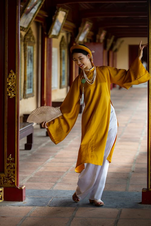 Woman Wearing Traditional Clothing and Holding Fan