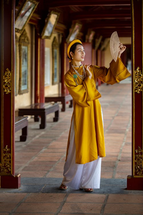 Woman Wearing Traditional Clothing and Holding Fan