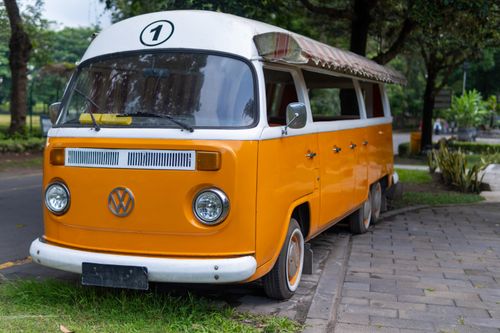 Free A classic orange Volkswagen camper van parked on a street in Yogyakarta, Indonesia. Stock Photo