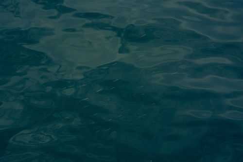 Free A close-up view of dark rippling water creating subtle patterns on its surface. Stock Photo