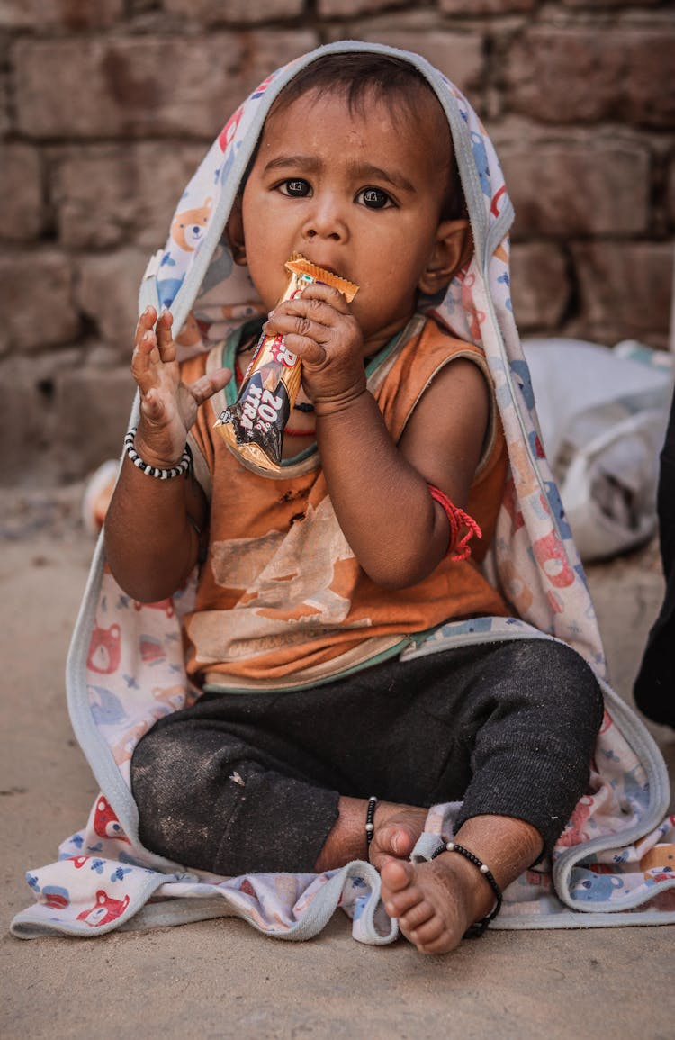 Portrait Of A Baby Boy Eating A Chocolate Bar