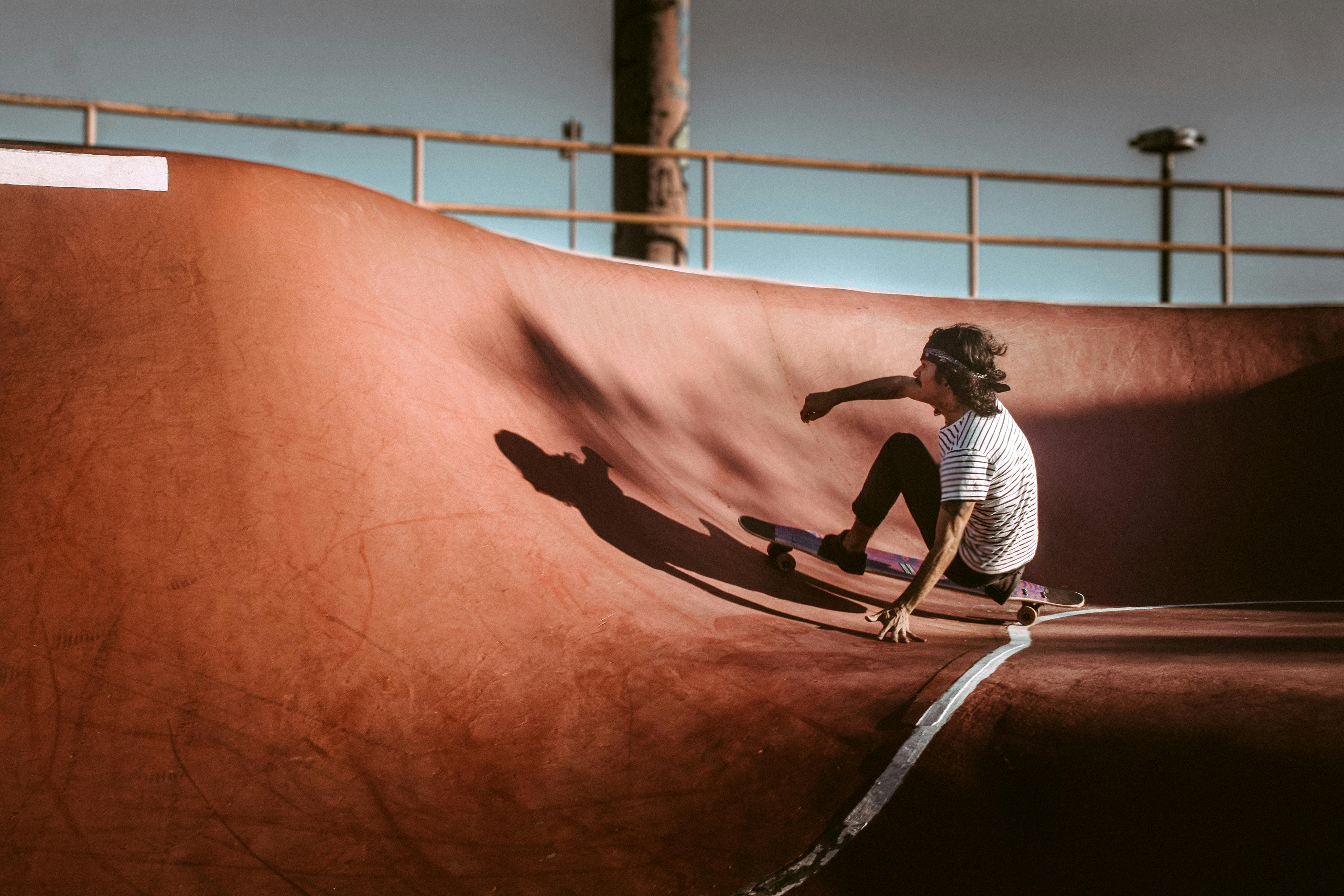 A man skateboarding in a skatepark bowl, showcasing dynamic urban lifestyle.