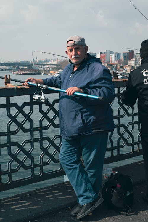 Senior Man Fishing in a City Harbor