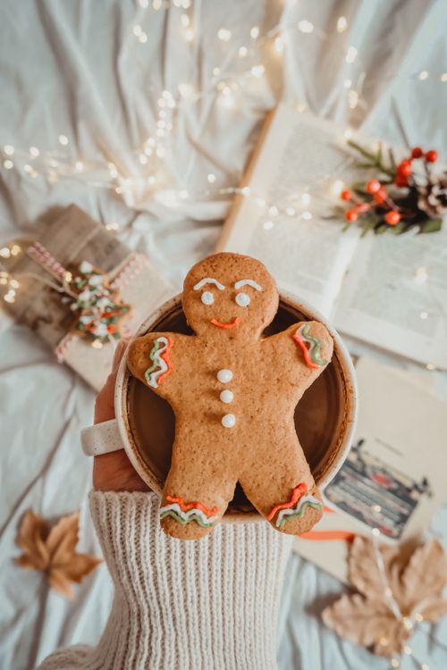 Free A warm ceramic mug holding a festive gingerbread man, perfect for a cozy winter atmosphere. Stock Photo