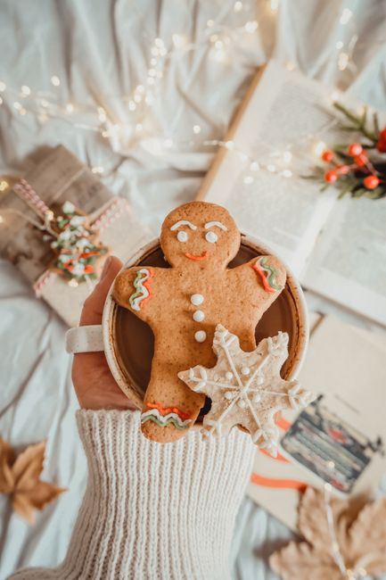 Warm winter moment with a gingerbread man and festive drink in a cozy setting.