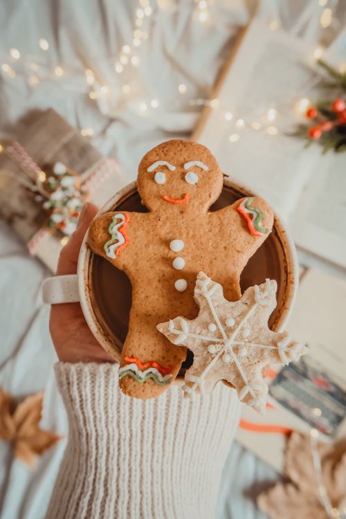 Free A warm gingerbread man and snowflake cookie placed on a cozy mug, perfect for winter festivities. Stock Photo