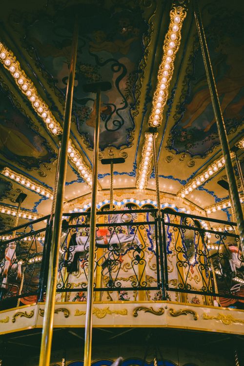Free A beautifully illuminated vintage carousel with intricate designs and glowing lights at night. Stock Photo