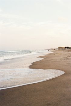 Serene beach with soft waves and a calming horizon, perfect for peaceful moments.